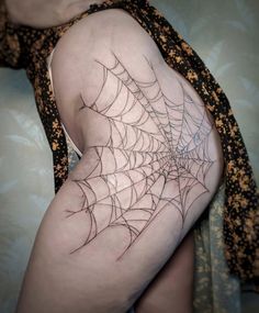 a woman with a spider web tattoo on her thigh