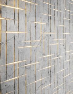 a white marble wall with gold lines on it