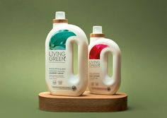 two bottles of living green liquid sitting on top of a wooden stand against a green background