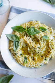 a white bowl filled with pasta and herbs