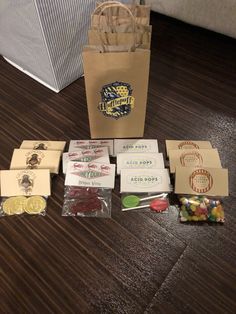 several bags and some candy are on the floor next to a paper bag with stickers