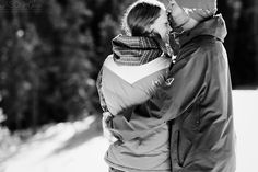 a man and woman are kissing in the snow