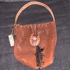 Brand New Never Used Sharpshooter Bucket Purse Tooled Baddle Leather Hand Antiqued/Hand Laced/Hand Painted Real Feathers And Buckle Handmade Leather Hobo Bag In Pouch Shape, Everyday Hand-tooled Leather Pouch, Leather Bucket Hobo Bag With Snap Closure, Leather Hobo Bag With Removable Pouch As Fashion Accessory, Brown Leather Bucket Bag With Snap Closure, Brown Bags With Snap Closure For Gift, Handmade Leather Bags, Skull Bags, Bucket Purse