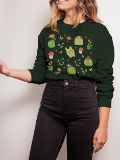 This cute cottagecore sweatshirt features a collage of frogs among mushrooms and strawberries. This trendy design will your new favorite sweatshirt that you reach for again and again. * Q U I C K * F A C T S * ♥ Solid colors are 100% cotton ♥ Heather colors are cotton/poly blend ♥ Design is high quality digital print ♥ Wash and dry normally (on cool for best results) * S I Z I N G * ♥ Sizing is unisex so runs like men's, though not overly large ♥ Most women find their typical size works best, si Frog Sweater, Cottagecore Sweatshirt, Goblincore Clothes, Cottage Core Clothes, Frog Sweatshirt, Clothing Kawaii, Aesthetic Crewneck, Job Clothes, Fruit Shirt