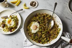 two bowls filled with food on top of a white marble counter next to lemons