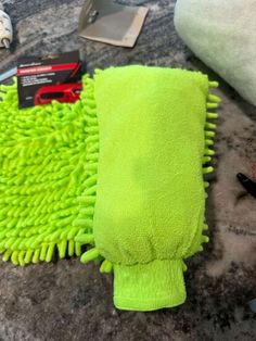 a pile of green towels sitting on top of a counter next to a pair of scissors