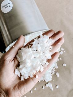 a person is holding some white food in their hand and it's on top of a flask