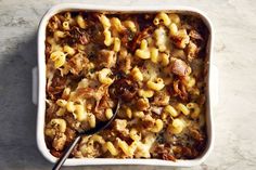 a casserole dish filled with macaroni and cheese, meat and vegetables