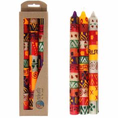 two multicolored crayon candles in a cardboard box next to each other