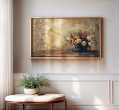 a painting hanging on the wall next to a table with a potted plant in it