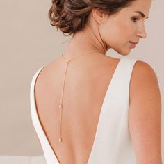 the back of a woman's neck wearing a gold necklace