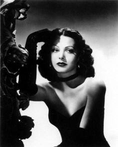 an old black and white photo of a woman with her hair styled in curls, posing for the camera