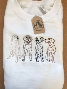 three dogs on a white shirt with a tag