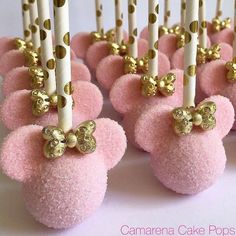 there are many pink cake pops with gold bows on them in the shape of teddy bears