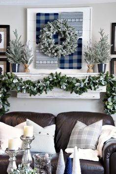 a living room decorated for christmas with greenery and wreaths on the mantel