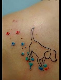 a small dog tattoo on the back of a woman's left shoulder, with sprinkles all over it