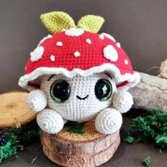 a crocheted mushroom hat sitting on top of a piece of wood