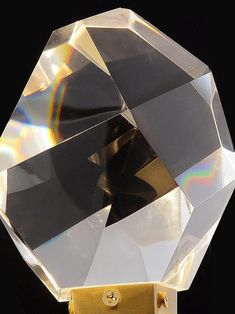 a diamond shaped object is shown against a black background with light coming from the top