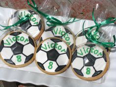 cookies decorated with soccer balls and ribbons on a table