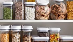 the shelves are filled with different types of food in glass containers and plastic containers on top of each other