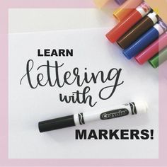 markers and crayons sitting on top of a piece of paper that says learn lettering with markers