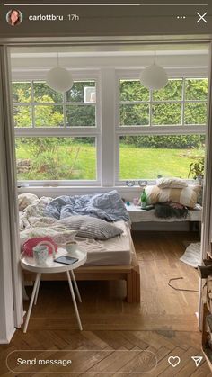 a bed sitting in the middle of a bedroom next to a window with lots of windows