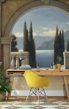 a desk with a yellow chair in front of a painting