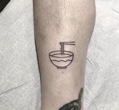 a man with a tattoo on his leg has a bowl of soup and a spoon