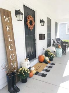 front porch decorated for fall with pumpkins, mumstats and welcome home sign