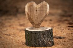 a wooden heart on top of a tree stump