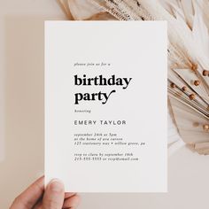 a person holding up a birthday party card with feathers around it and the words'birthday party'printed on it