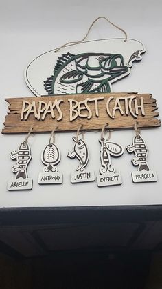 a sign that says papas best catch and six different key chains hanging from it