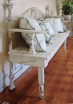 a white bench with pillows on top of it