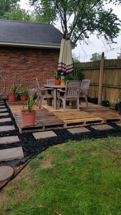 an outdoor patio with stepping stones and potted plants