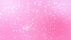 pink and white blurry background with snow flakes on the bottom right corner,