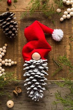 an elf is sitting on top of pine cones and other christmas decorations, including ornaments