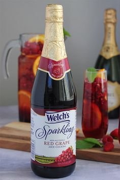 a bottle of wine sitting on top of a table next to some glasses and fruit