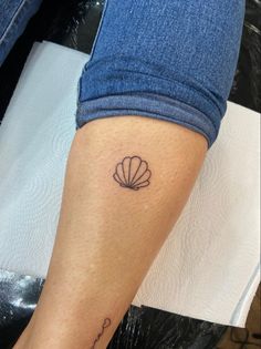 a woman's leg with a small tattoo on the side of her left arm