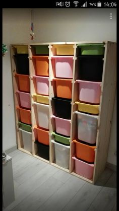 the shelves are filled with many different colored bins