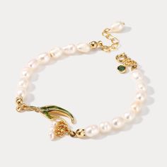 This exquisite Lily Of The Valley Pearl Bracelet is sure to add a touch of sophistication to any ensemble. Crafted with the finest enamel and pearls, its classic design makes it the perfect addition for any occasion. Timeless and elegant, it will be sure to turn heads.  >> See   More  Lily of the Valley   Jewelry   Collection. DETAILS Materials:   18K Gold on brass, Enamel, Freshwater Measurements: Length: 6.10"(15.5cm) + Extender: 2.36"(6.0cm) Weight:  9.91g Note: It will be in stock in 10-15 b Gold Flower Pearl Bracelet For Wedding, Elegant White Bracelet As A Gift, Elegant White Bracelet Suitable For Gifts, Wedding Pearl Charm Bracelet, Elegant Green Gold Bracelet For Wedding, Green Pearl Charm Jewelry For Wedding, Dainty Green Bracelets For Wedding, Dainty Green Wedding Bracelets, Gold Flower Charm Bracelet For Weddings