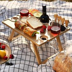 a picnic table with bread, fruit and wine on it