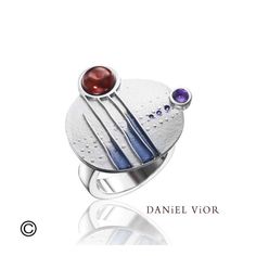 This intergalactic ring features a garnet and amethyst that are artfully bezel set and arranged on a flat medallion design, giving it a contemporary space-age look. Inspired by the beauty of asymmetry, raised lines and dots give this pretty ring added dimension, finished with streaks of colorful enamel.  This beautiful ring is made with a flat, square-edged band that allows it to lay comfortably when worn Modern Multi-stone Rings, Modern Amethyst Ring With Polished Finish, Modern Amethyst Ring With Bezel Setting, Modern Round Collectible Jewelry, Modern Sterling Silver Amethyst Ring, Modern Amethyst Ring Gift, Modern Amethyst Ring As Gift, Modern Round Amethyst Ring Gift, Modern Amethyst Jewelry