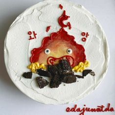 a white cake with red icing and an image of a monster on it's face