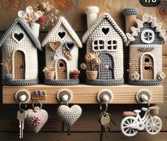 there are many small crocheted houses hanging on the wall with keychains