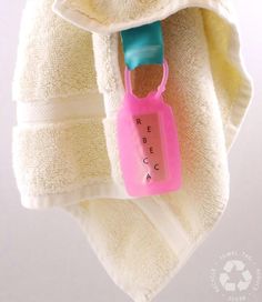 a white towel with a pink tag hanging from it's side on a hook