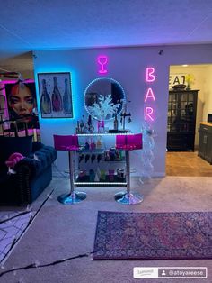 a living room filled with furniture and neon lights on the wall above it's bar