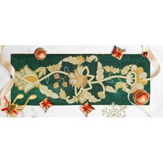 a green table runner with gold and red decorations