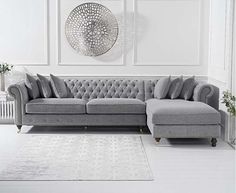 a living room with a gray couch and white rug