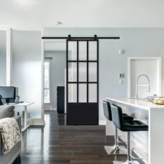 a living room filled with furniture next to a kitchen