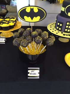 a table topped with batman cupcakes and cake pops